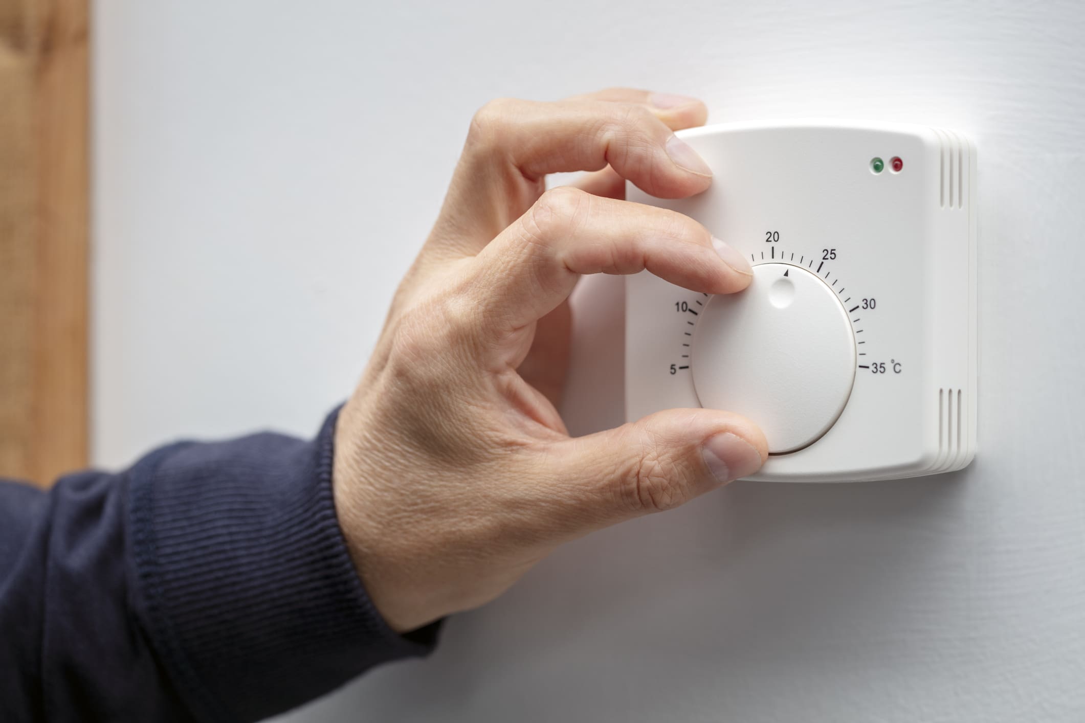 központi fűtés termosztátot állítja be egy férfikéz