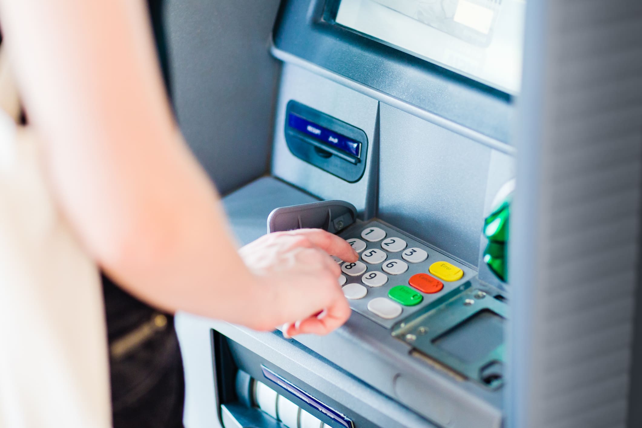 Egy nő ATM-ből vesz fel készpénzt.