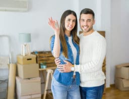 Egy fiatal pár beköltözött új otthonába, a nő mutatja a kulcsot.