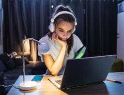 egyetemista lány laptop előtt asztalnál tanul a saját lakásában