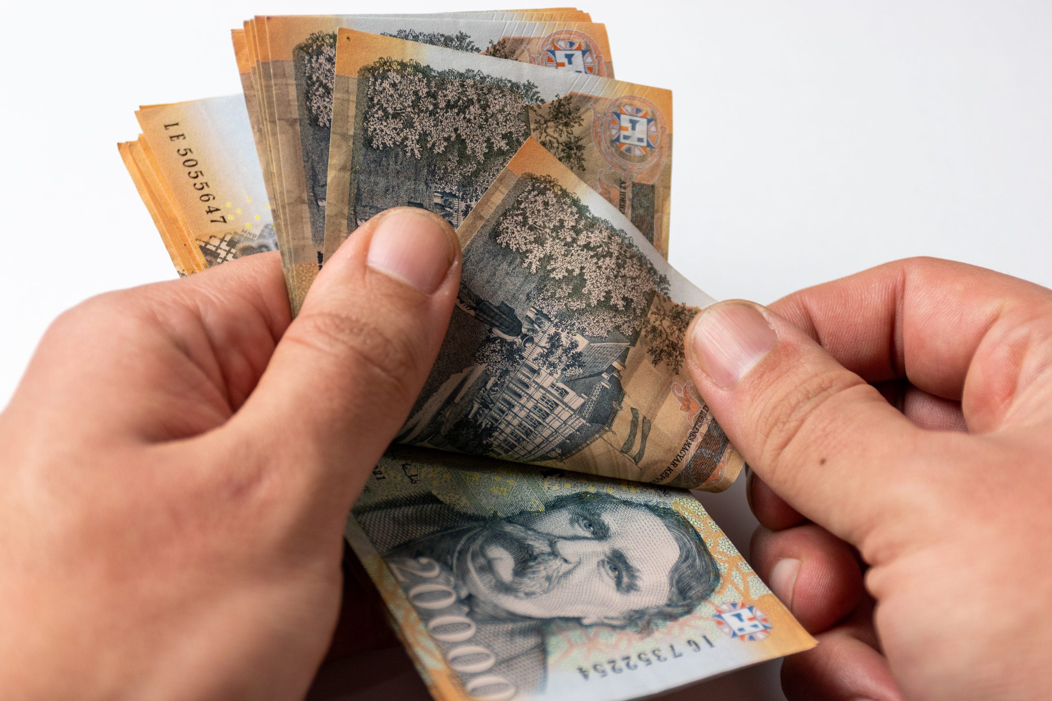 Magyar húszezres forint bankjegyek számolása kézben