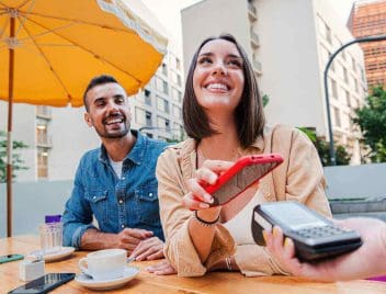 fiatal pár fizet a kávéért telefonnal, revolutról átutalás