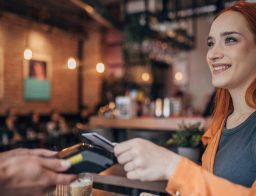 nő a kávézóban bankkártyával fizet, miután az MNB kigyűjtötte a legolcsóbb bankszámlákat