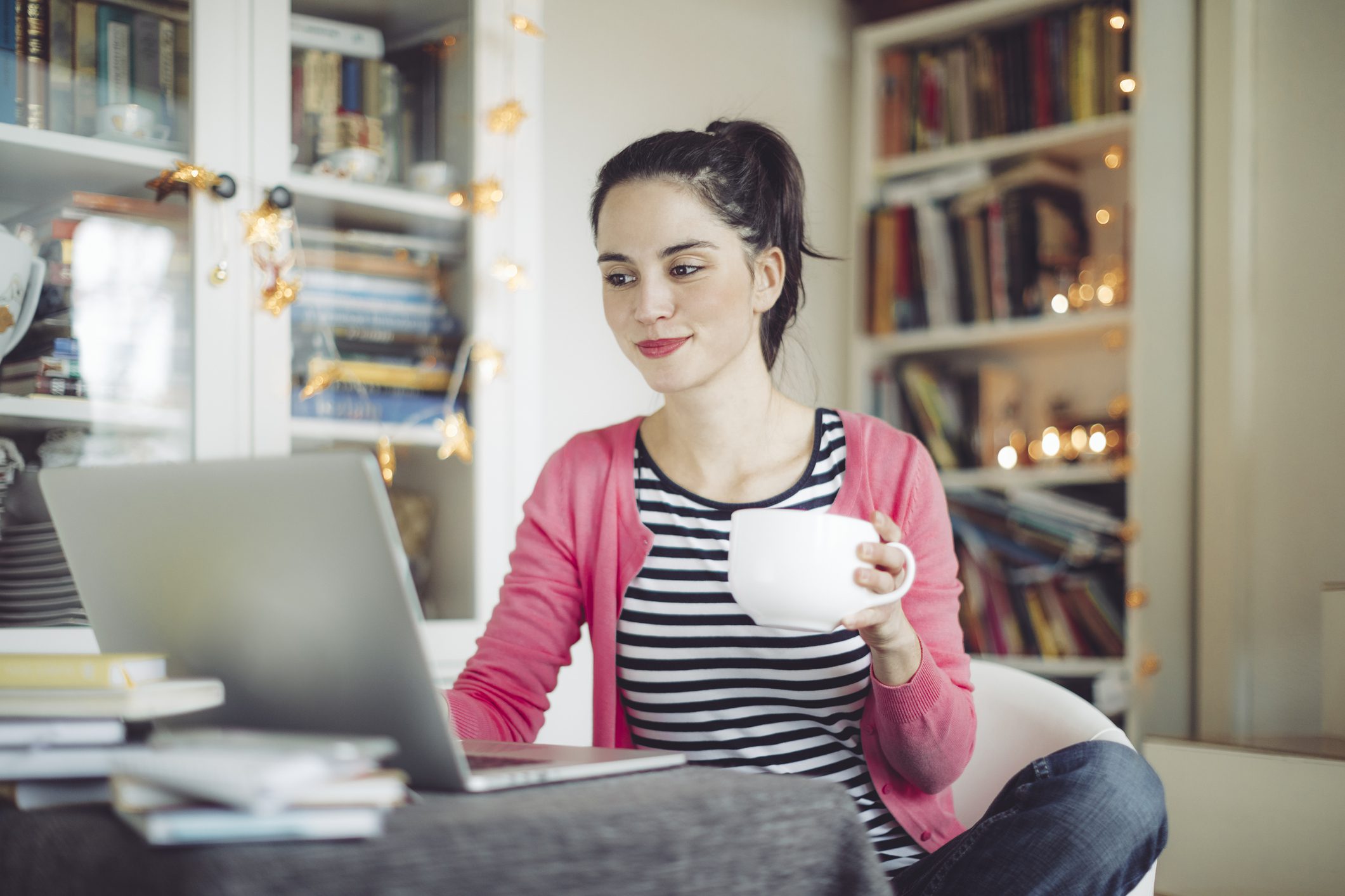 Ügyek intézése otthonról: egy fiatal nő az internet előtt a laptopján intézi banki ügyeit.