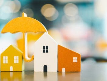 minősített fogyasztóbarát otthonbiztosítást jelképező házikók, esernyő, lakásbiztosítás