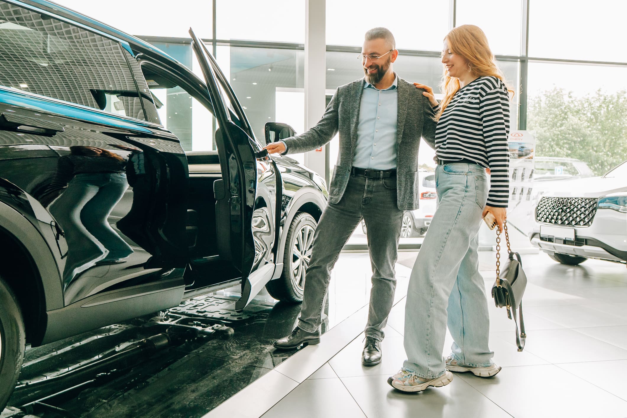 Autószalonban egy pár autókat nézeget