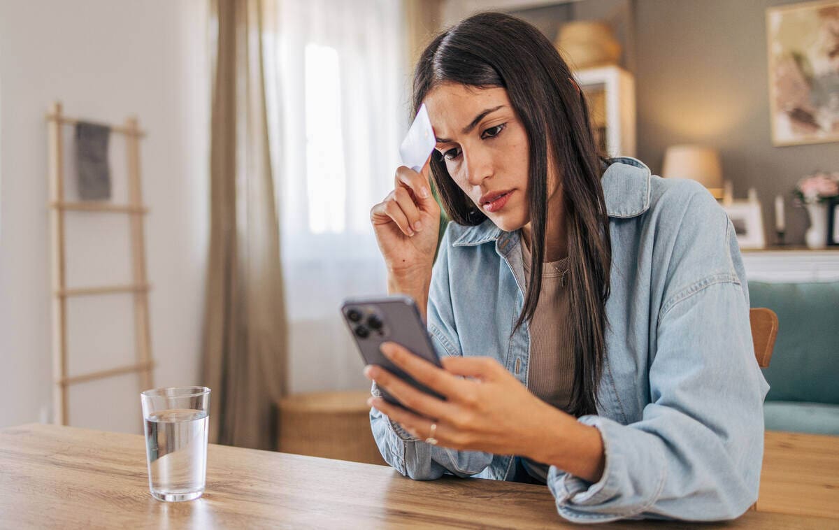 nő a mobilbankján nézi, hogy új és drágább számlacsomagba került