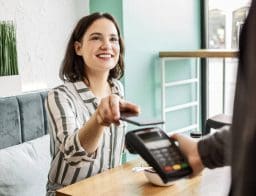 nő telefonnal fizet a legolcsóbb bankszámláról