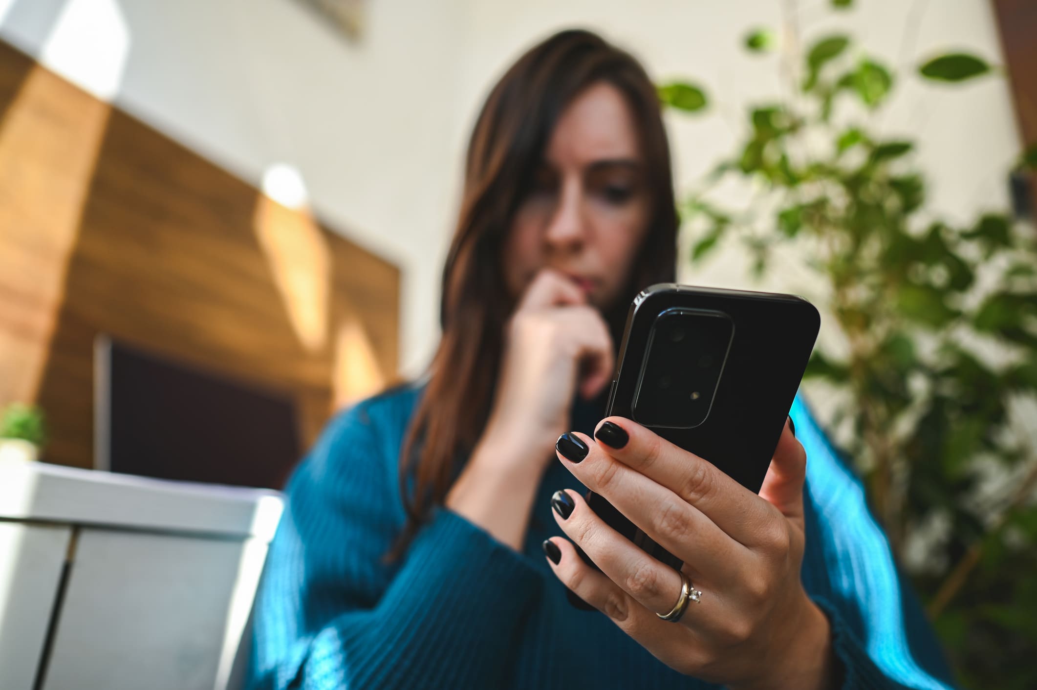Gyanús üzenet észlelése a mobiltelefonon egy fiatal nő által.