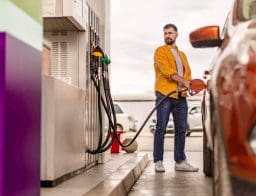 férfi védett áras benzint tankol a benzinkúton