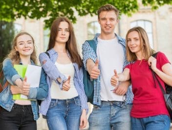 Fiatal középiskolások like jelet mutatnak az ujjukkal négyen