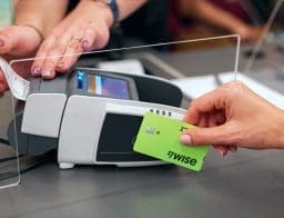 nő Wise-kártyával fizet a pos-terminálnál, miután feltöltötte pénzzel, qvik-kérelem