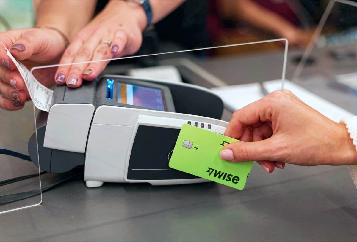 nő Wise-kártyával fizet a pos-terminálnál, miután feltöltötte pénzzel, qvik-kérelem